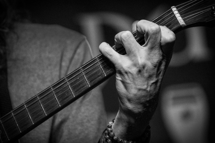 Clost up of hand playing guitar.